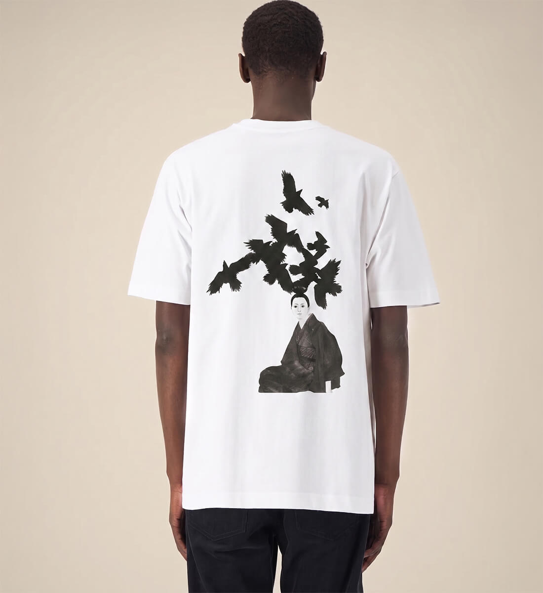 Mann trägt Unisex Oversized Streetwear T-Shirt in Weiß, massiver Backprint mit handgezeichneter japanischer Frau und fliegenden Raben aus schwarzer Tusche, Mugen no Karasu